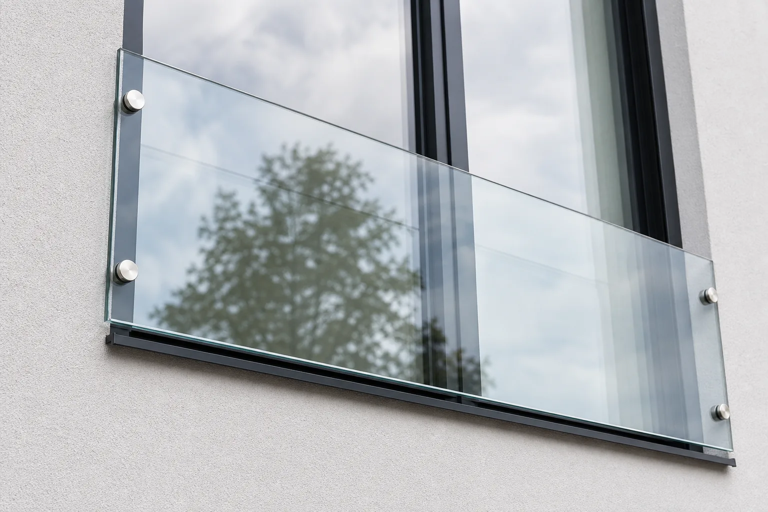 Detailansicht einer Absturzsicherung mit Glasgeländer vor einem bodentiefen Fenster