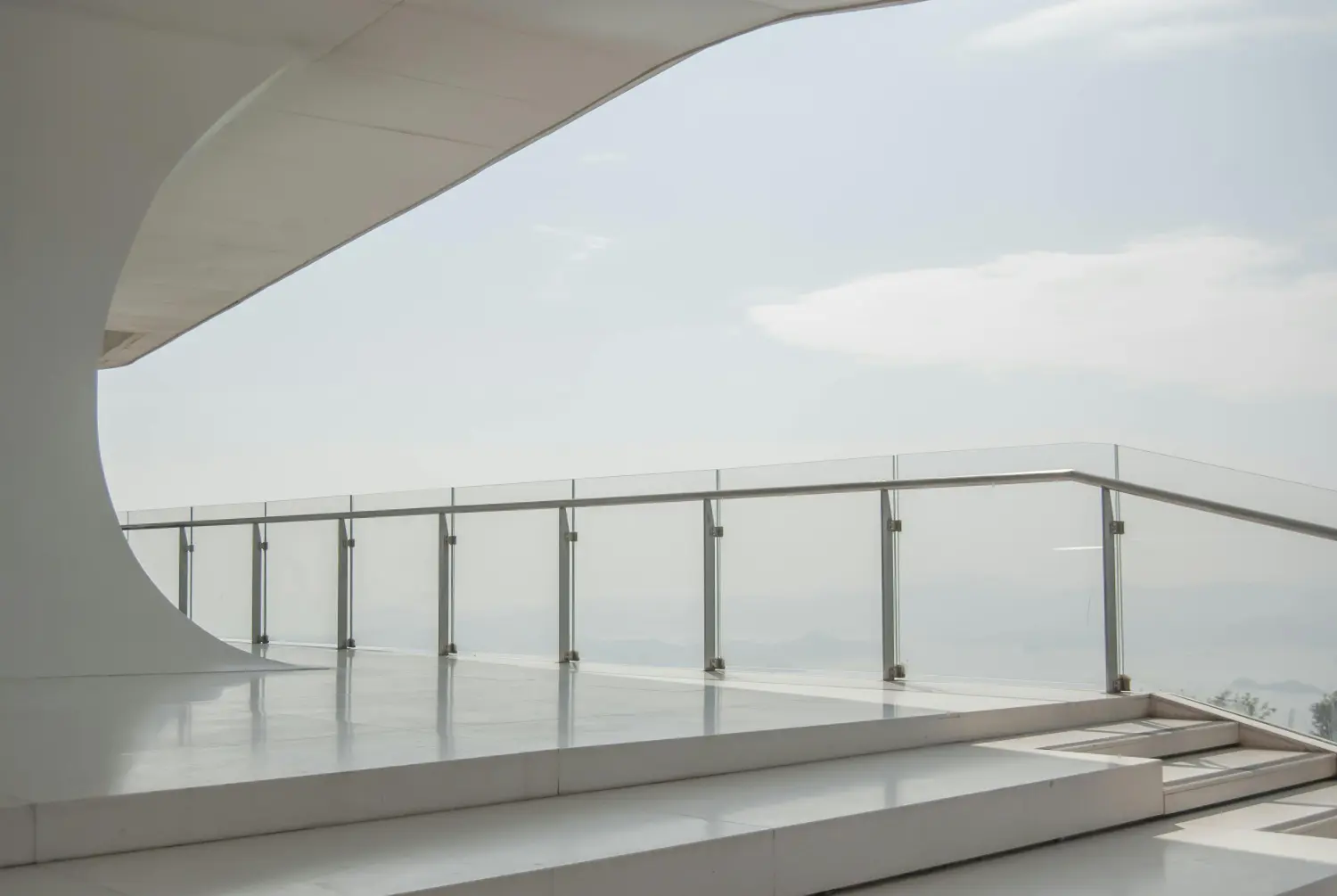 Modernes Terrassendesign mit einer Brüstungsverglasung und freiem Ausblick