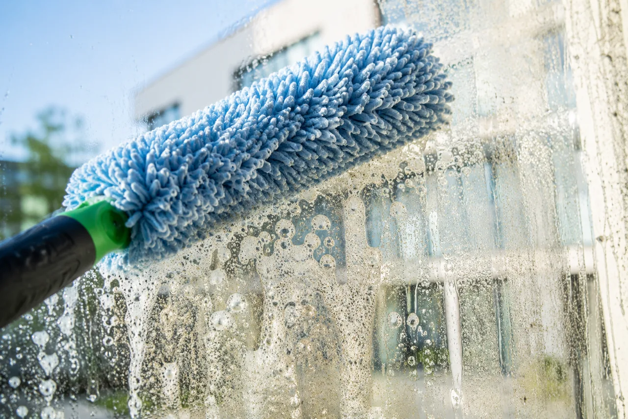 Professionelle Fensterreinigung mit streifenfrei geputzter Glasscheibe.