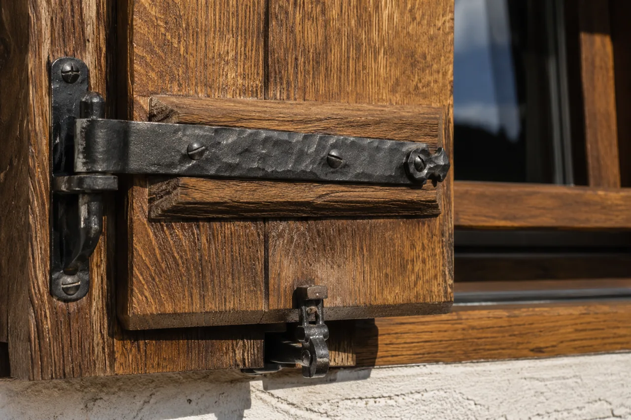 Klassische Fensterläden aus Holz an der Fassade eines Wohnhauses.
