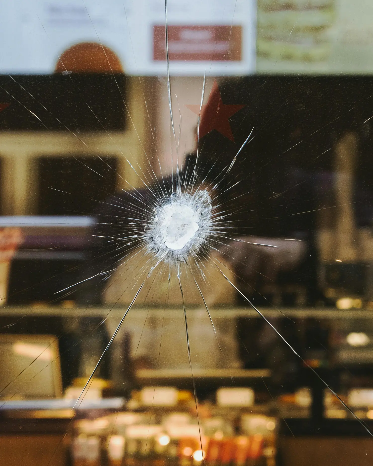 Ein großes, zersplittertes Schaufenster eines Geschäfts nach einem Einbruchsversuch.